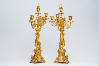 A pair of French gilt bronze five-light candlesticks with putti and floral design, 19th C.