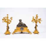 A French gilt and patinated bronze three-piece clock garniture crowned with a putto playing with a b