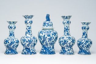 A Dutch Delft blue and white five-piece vase garniture with peacocks on a rock, 19th C.