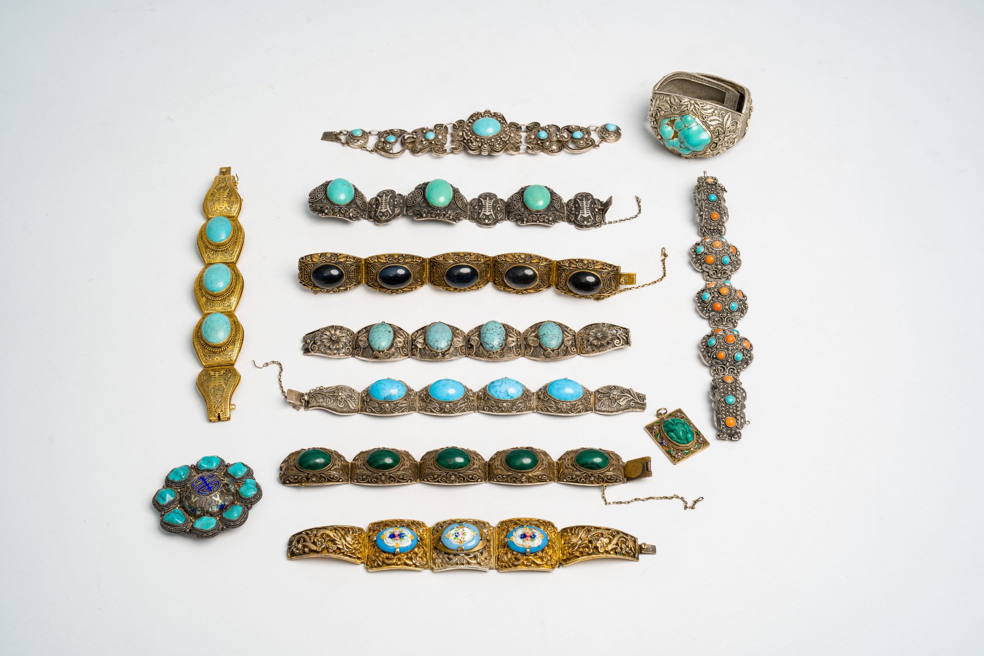 Ten mostly Chinese partly gilt and hardstone-inlaid silver bracelets, a pendant and a brooch, 19th/2