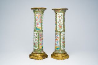 A pair of Chinese Canton famille rose gilt bronze mounted sleeve vases with palace scenes, 19th C.