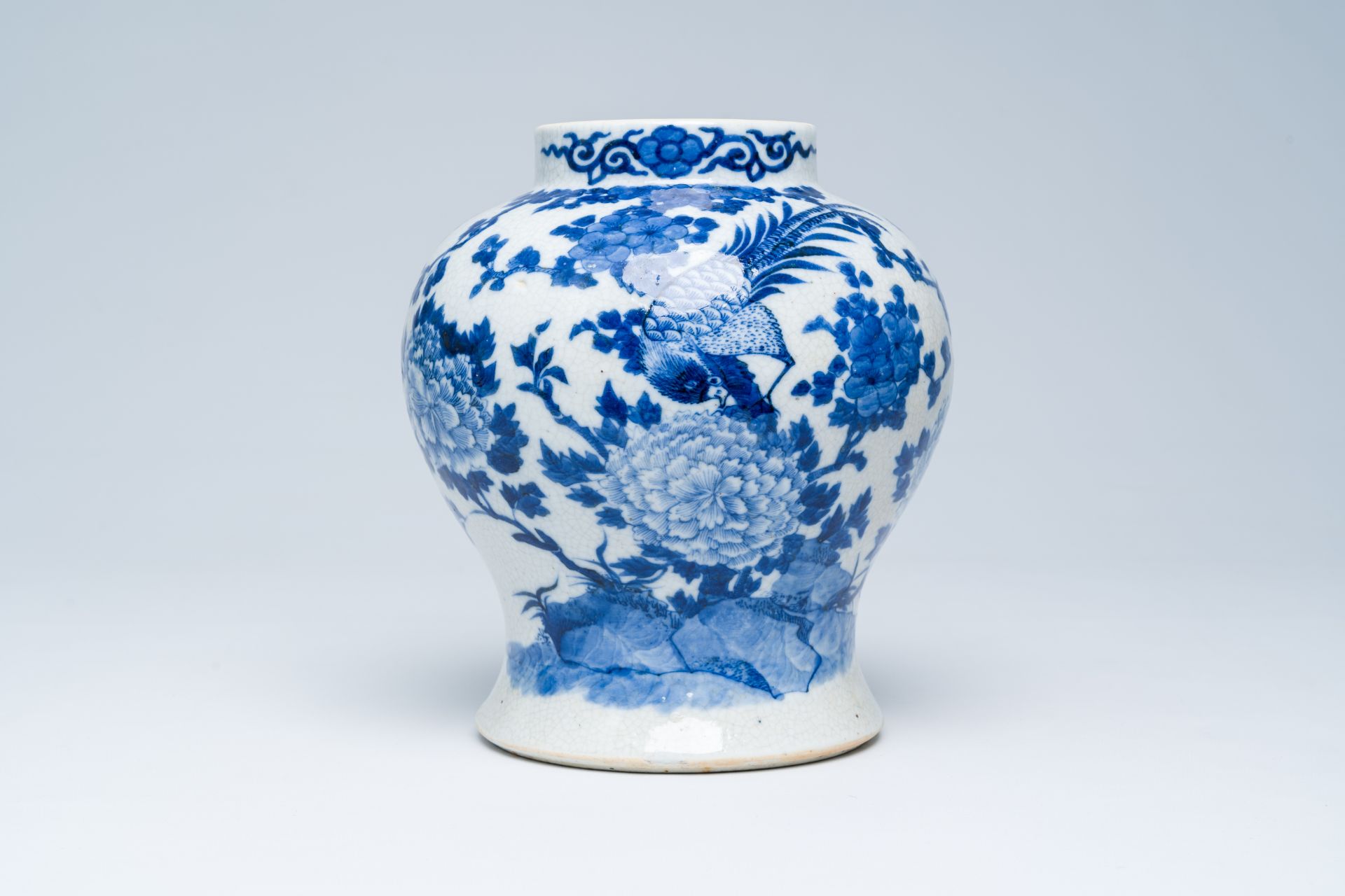 A Chinese crackle glazed blue and white vase with a bird among blossoming branches, 19th C.