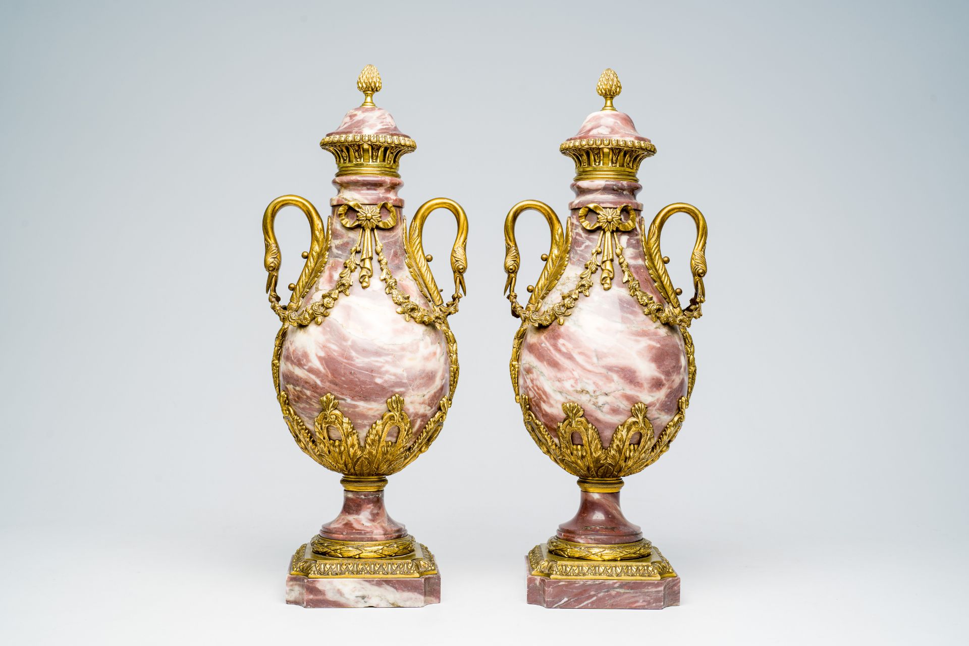 A pair of French bronze mounted Empire style marble cassolettes wit swan necks and floral design, 19