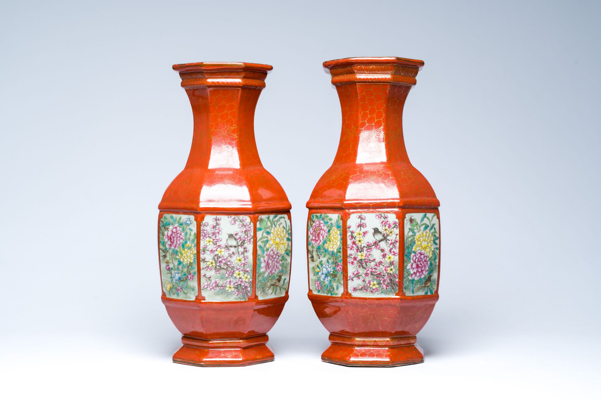 A pair of Chinese famille rose coral-red ground vases with birds among blossoming branches, Qianlong