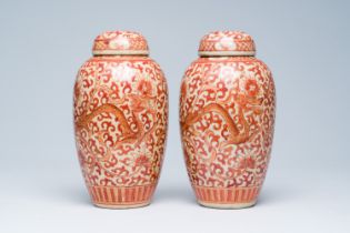 A pair of Chinese crackle glazed iron-red jars and covers with dragons among lotus scrolls, 19th C.