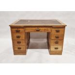 Early 20th century oak desk with leather inset to top, an arrangement of nine drawers around the