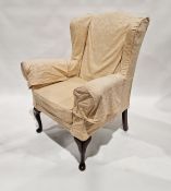 Yellow upholstered wing armchair on mahogany cabriole supports