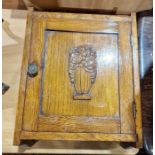20th century oak wall cupboard with relief flower moulding to panelled door, 30cm wide