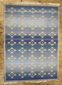 Woven wool rug of Eastern design, the blue field with nine rows of five beige geometric