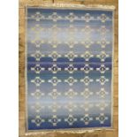 Woven wool rug of Eastern design, the blue field with nine rows of five beige geometric