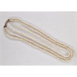 Triple string of baroque pearls with gold-coloured metal clasp
