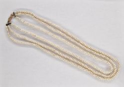 Triple string of baroque pearls with gold-coloured metal clasp