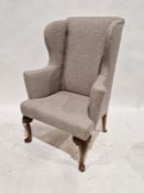 Grey upholstered wingback armchair with red upholstered seat
