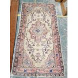 Modern wool pile pink ground rug with central floral medallion on a floral field with spandrels,