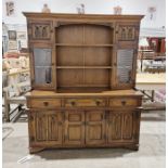 Oak kitchen dresser, the top section with two shelves flanked by single door glazed cupboard and