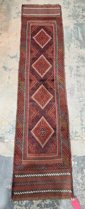 Meshwani red ground wool runner with one row of four lozenge medallions and multiple geometric