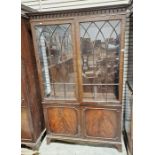 Mahogany glazed display cabinet with two glazed doors raised over a two-door cupboard, with fitted