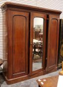 Victorian mahogany compactum with moulded cornice above three doors centred by a mirror, flanked