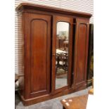 Victorian mahogany compactum with moulded cornice above three doors centred by a mirror, flanked