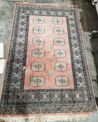 Pakistani hand knotted peach ground wool pile rug with two rows of six elephant foot guls,