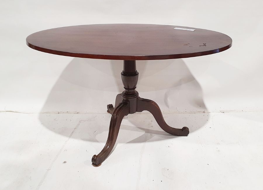 Early 19th century mahogany table, the oval top on turned baluster pedestal and reeded tripod