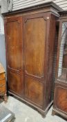 Mahogany two-door wardrobe with carved geometric decoration to the pediment, raised on splayed