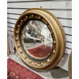 Early 20th century gilt framed convex wall mirror of circular form, adourned with gilt ball
