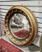Early 20th century gilt framed convex wall mirror of circular form, adourned with gilt ball