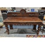 Large Victorian oak buffet table with carved decoration including depiction of lions and birds