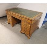 Burr walnut veneer twin pedestal desk with gilt tooled leather top, having a central long drawer