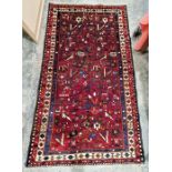 North West Persian red ground Afshar rug with all-over floral and stylized animal pattern,