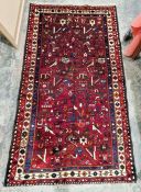 North West Persian red ground Afshar rug with all-over floral and stylized animal pattern,