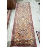 North West Persian Heriz orange ground runner with one row of five floral medallion on a floral