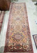 North West Persian Heriz orange ground runner with one row of five floral medallion on a floral