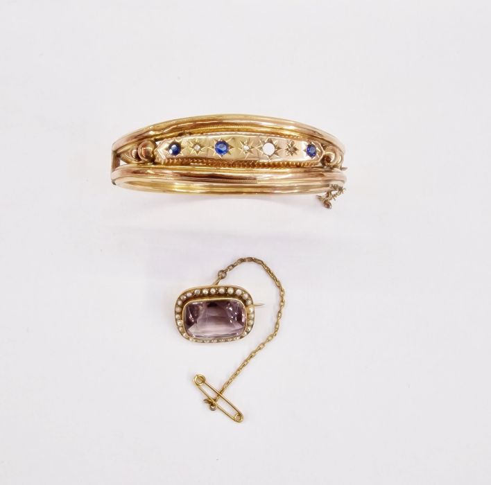 A 9ct gold bangle set with three small diamonds and blue stones (one missing), 11g approx. and a