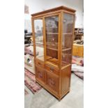 Chinese hardwood display cabinet, the glazed two-door cabinet opening to reveal two fitted