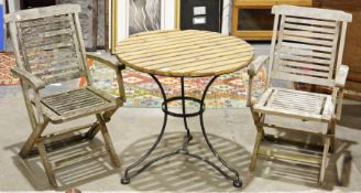 Circular garden table on cast iron tripod base and two wooden folding garden chairs