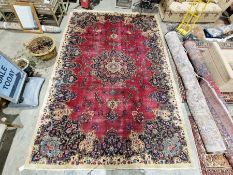 North East Persian Signed red ground Meshed carpet with large centralised floral medallion