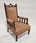 Victorian mahogany armchair with leopard print upholstery, on turned supports and castors