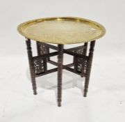 Middle Eastern brass circular tray-top occasional table with hammered decoration of a warrior riding