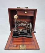 Mid to late 19th century sewing machine by James Weirs, in mahogany cabinet with accessories, 28cm