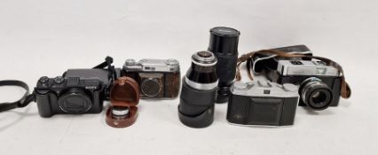 Assorted cameras to include various Kodak vintage and later cameras, a Vivitar lens, an AGFA