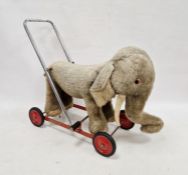 Merrythought elephant on wheels, grey and cream plush with bell, chrome handle, on red metal base,