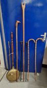 Brass lidded warming pan, two walking sticks made from bamboo, a carved wooden thumbstick, another