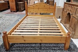 Pine double bed with arched headboard, slatted base and turned ball feet and finials, 101cm high x