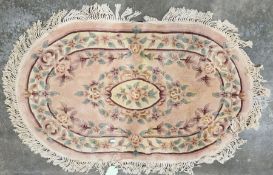 Chinese orange ground oval superwash rug with central floral medallion, single floral border 154cm x