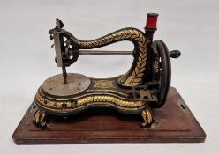 Late 19th century Jones hand sewing machine, decorated throughout with ornate gilt motifs on a black