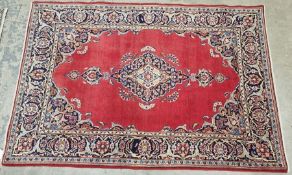 Central Persian red ground Kashan rug with central floral medallion, floral spandrels and multiple