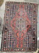 Mouallem red ground rug with central floral lozenge enclosed by geometric pattern, multiple