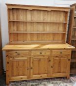 Pine dresser having two-tier plate rack above base with three drawers and three cupboards, brass